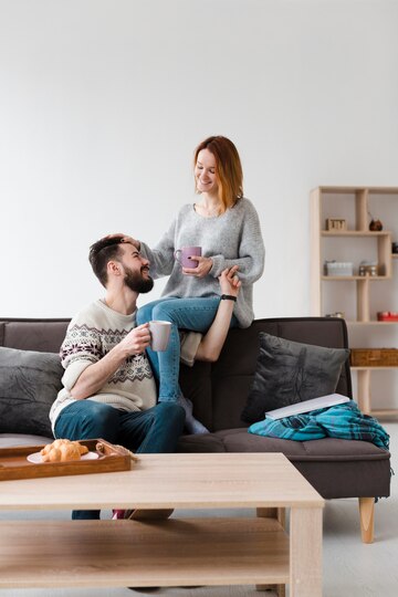 couple-living-room-sitting-couch_23-2148450222